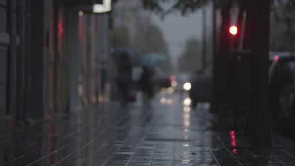 Размытый вид на мощеную улицу в дождливый вечер — стоковое видео