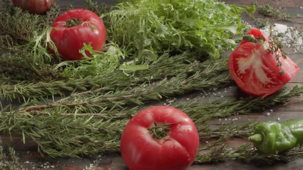 Χορτοφαγικά στρωμένα στο τραπέζι. Νωπά βότανα, σαλάτα και ντομάτες — Αρχείο Βίντεο