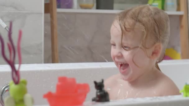 Niña jugando en el baño y salpicando agua — Vídeos de Stock