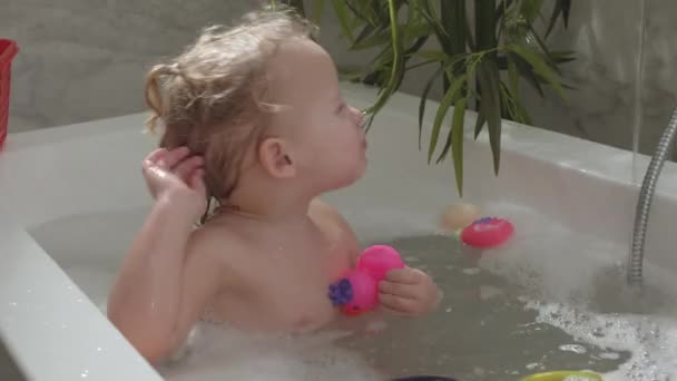 Verspieltes kleines Kind in der Badewanne — Stockvideo