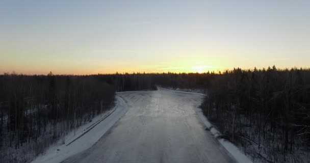 日出时分冬季森林和冰冻河流的空中景观 — 图库视频影像