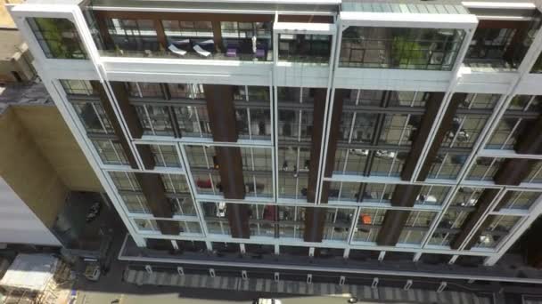 Immeuble moderne avec reflet de rue en façade vitrée, aérienne — Video
