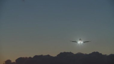 Plane flight over the clouds in evening sky