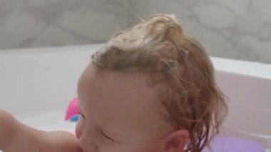 Erkek kardeşiyle banyo yapan küçük bir kızın yakın çekimi.