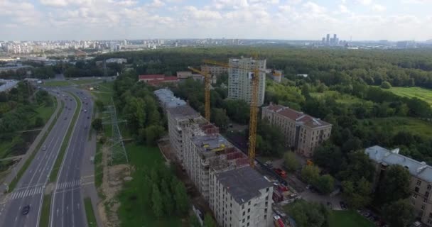 Вид с воздуха на многоэтажное здание рядом с автомагистралью — стоковое видео