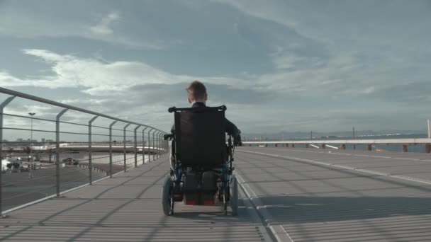 Gehandicapte jongen in elektrische rolstoel buiten — Stockvideo