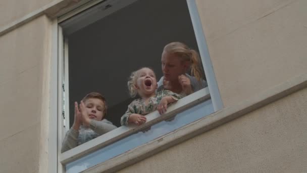 Family in open window during Covid-19 quarantine — Stock Video