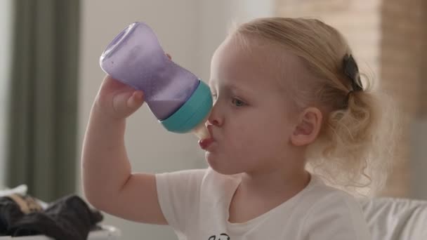 Kisgyermek tejet iszik az üvegből. — Stock videók