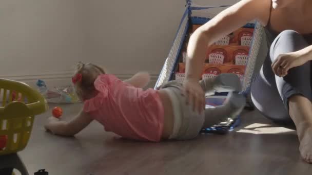 Rolling on the floor is fun for this little girl — Stock video