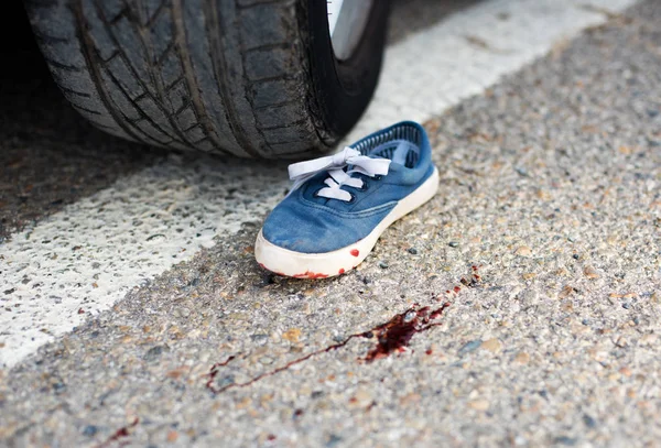 Shoes in the blood under the car wheels — Stock Photo, Image