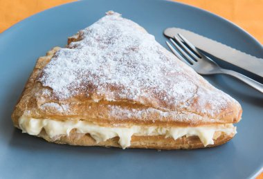 Kremalı çörek üçgen gri bir plaka üzerinde katlanmış