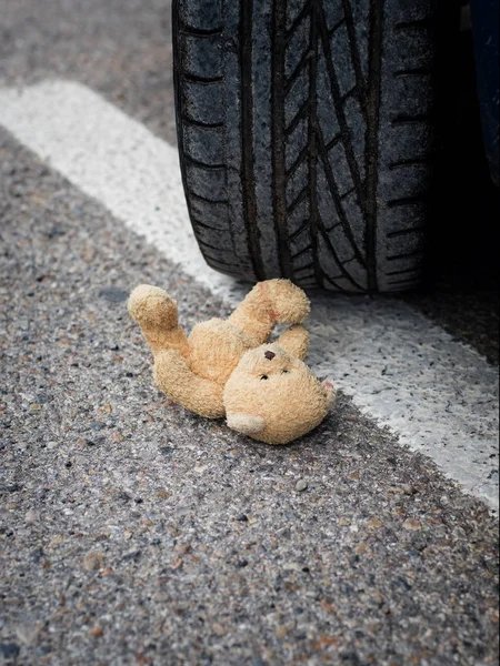 Orso giocattolo nel sangue sotto le ruote dell'auto — Foto Stock