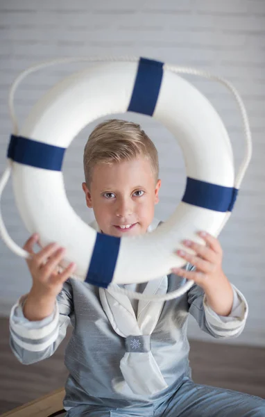 Carino marinaio ragazzo in possesso di un salvagente — Foto Stock
