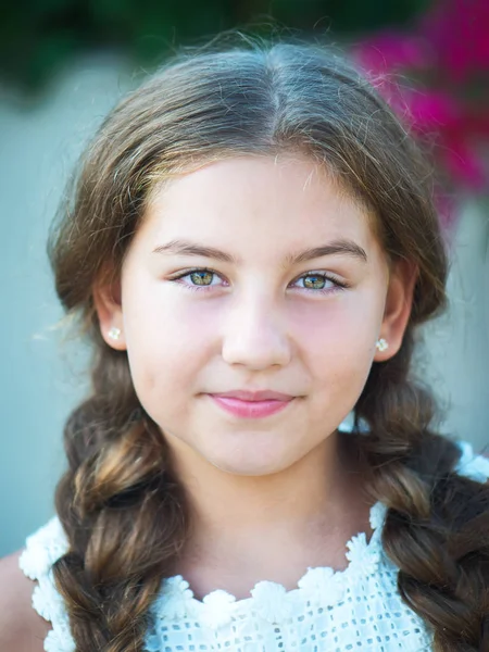 Beautiful little girl with braids on nature background — Stock Photo, Image