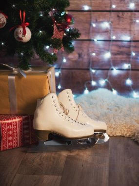 Eski bir deri çanta ve bir Noel ağacı yanındaki kadın patenler. Noel süsleri