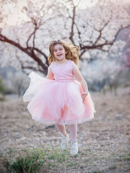 Menina bonita correndo através do parque de primavera — Fotografia de Stock