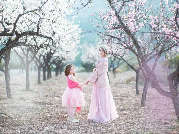 Moeder met haar dochter in perzik bloesem tuin — Stockfoto