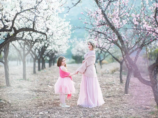 Mère avec sa fille dans le jardin de pêche en fleur — Photo