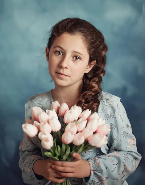 Foto van klein meisje met tulpen in handen over wit — Stockfoto