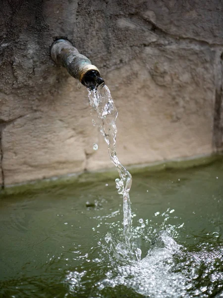 Tekoucí voda z kohoutku v parku. — Stock fotografie