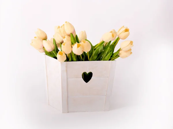 Tulipanes artificiales en una caja blanca con un corazón sobre un fondo blanco — Foto de Stock