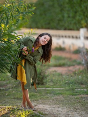 Doğada yeşil yağmurluklu şirin bir kız..