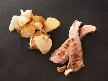 Koyu tabakta kızarmış patatesli ton balığı.