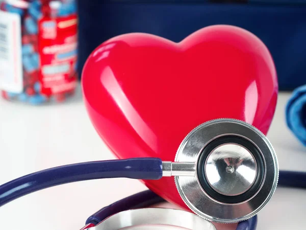 Corazón rojo y estetoscopio en la mesa del médico — Foto de Stock