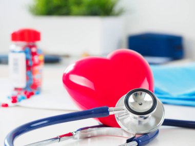 Kırmızı kalp ve doktor masada stetoskop