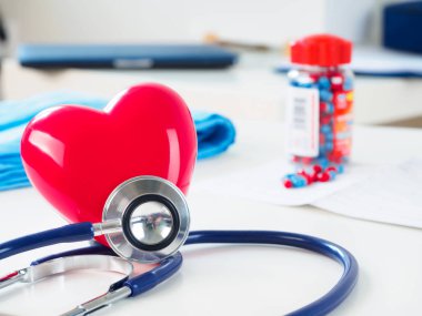 Kırmızı kalp ve doktor masada stetoskop