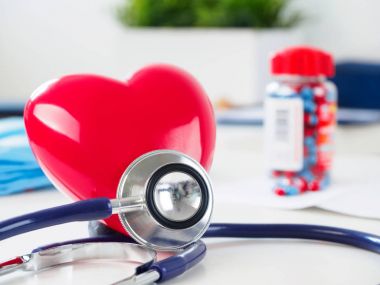 Kırmızı kalp ve doktor masada stetoskop