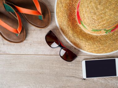 Hasır şapka, güneş gözlüğü, smartphone ve terlik