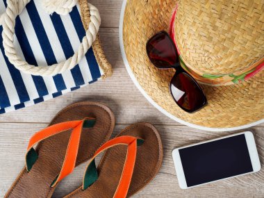 Hasır şapka, güneş gözlüğü, smartphone ve terlik