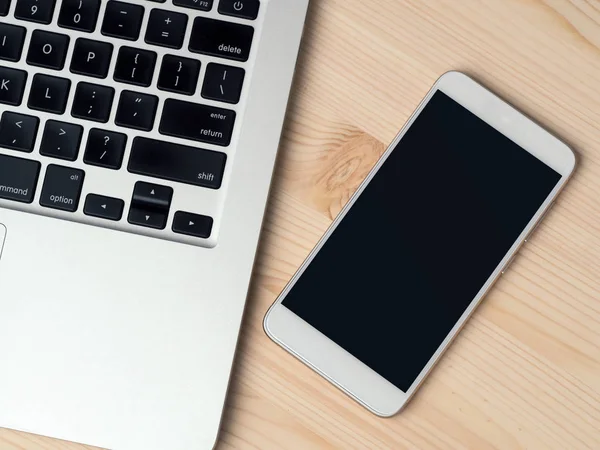 bilgisayar ve akıllı telefon ahşap masada.