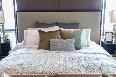 Yatak odasında yatak birçok yastık.