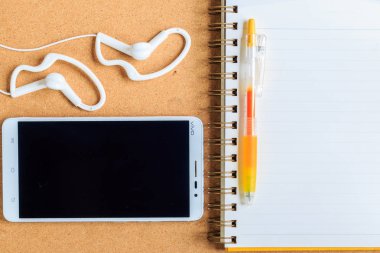 Kulaklık Beyaz b ile bir dizüstü bilgisayar ve cep telefonu üzerinde sarı kalem