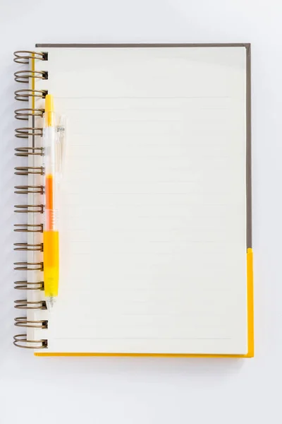 Un bolígrafo amarillo en el cuaderno en fondo blanco . —  Fotos de Stock