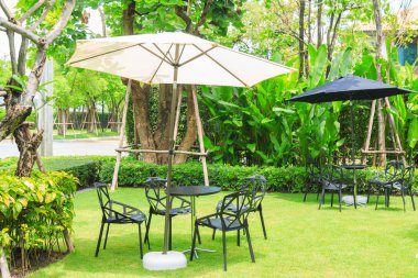 GA çimenlerin üzerinde beyaz şemsiye altında siyah masa sandalye