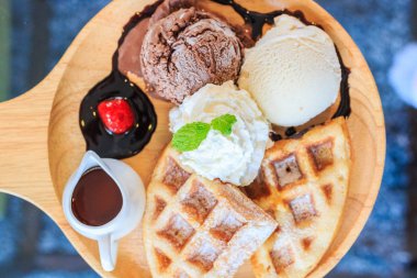 Dondurma waffle ve krem şanti çikolata chutneyberr tepesinde