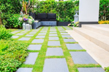 Bahçedeki çimlerin üzerine taş döşeme.