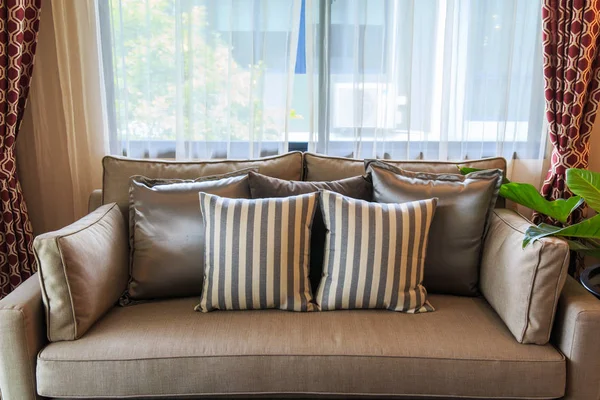 Muchas almohadas en un sofá de tela marrón . — Foto de Stock