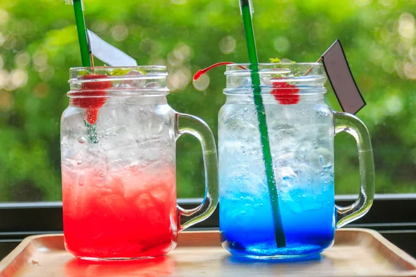 Çilekli soda ve ağaç duvar ile ahşap bir tepsi üzerinde mavi Hawaii 