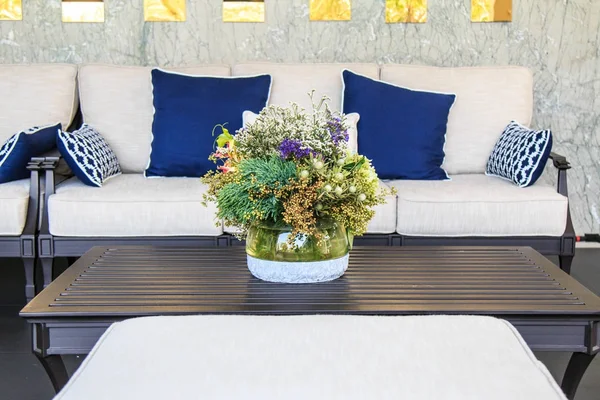 Krásná kytice ve skleněné váze na stole a pohovkou v obývacím pokoji. — Stock fotografie