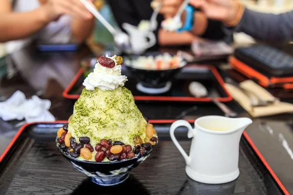 Tè verde bingsu con fagioli rossi dolci su tazza nera e vassoio nero — Foto Stock