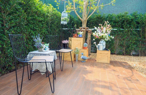 Venkovní židle a stůl s výzdobou na podlaze v zahradě. — Stock fotografie