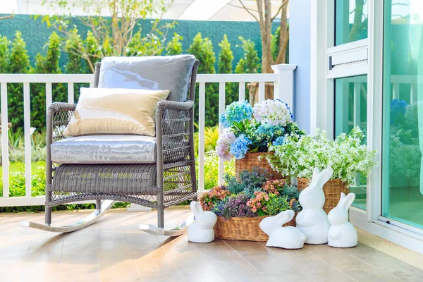 A wooden rocking chair and flowers in the basket on the wooden f — Stock Photo, Image