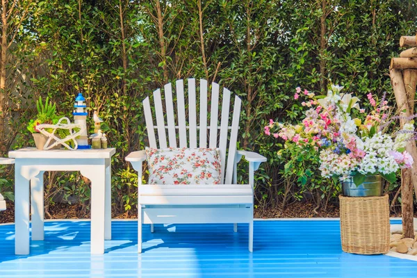 Tavolino e sedia con fiori in giardino . — Foto Stock