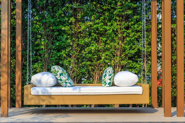 Venkovní pryskyřice proutěné houpací lavici v zahradě s přírodou ba — Stock fotografie