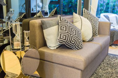 Siyah ve beyaz ile kahverengi kanepe üzerinde bir kum saati yan yastıklar 