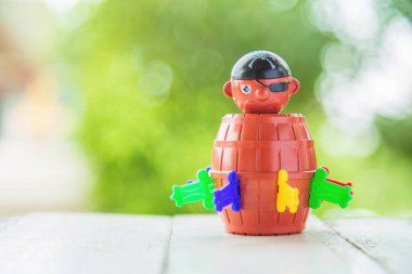  Beyaz ahşap masa üzerinde yeşil doğası bulanık korsan komik fıçı oyuncak kovası..